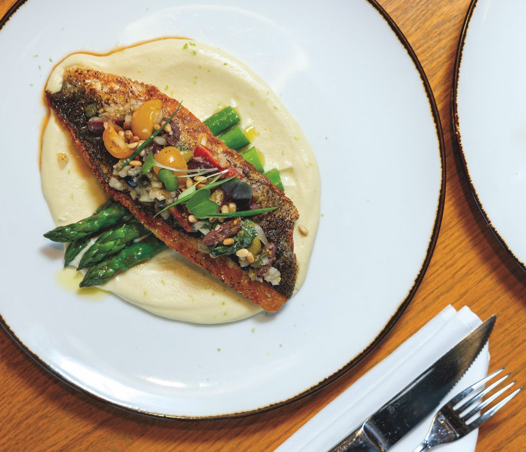 Grilled branzino served with vierge sauce, parsnip-apple puree, toasted pine nuts and basil.