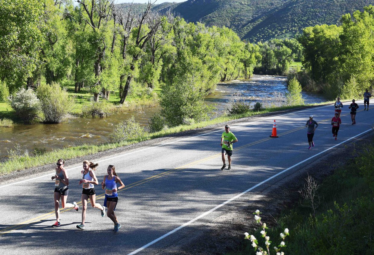 Runners fly along the Elk River on Sunday during the Steamboat Marathon.
