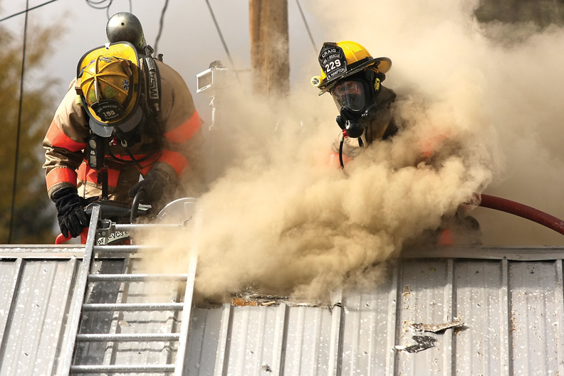 Craig Fire/Rescue firefighters cut a hole in the Craig Motel rooftop in efforts to contain a fire Wednesday. Firefighters worked inward from the edges of the fire back to the source after initial flames were subdued.
