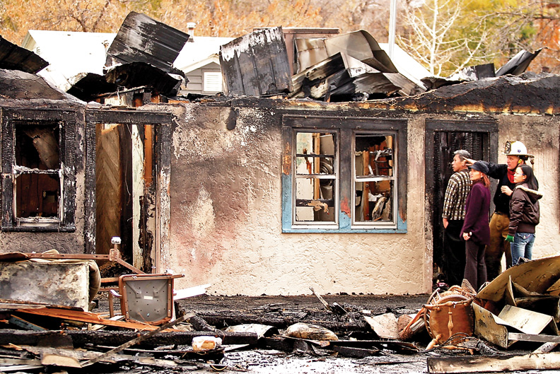 K.C. Hume, Craig Fire/Rescue battalion chief, goes over fire damages with Craig Motel manager Lisa Wu, her husband, Jimmy Dang, and friend Mei Curley. The fire damaged 16 of the motel's rooms.
