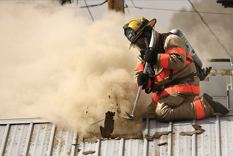 Craig Fire/Rescue firefighter Al Landa knocks through the roof to combat the fire at the Craig Motel. 
