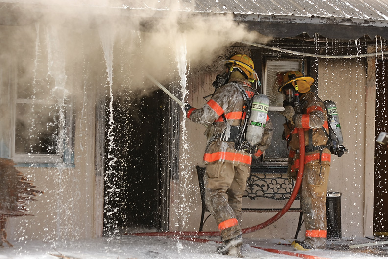 Craig Fire/Rescue officials spray foam fire retardant into the ceiling of the burning Craig Motel on Wednesday afternoon.
