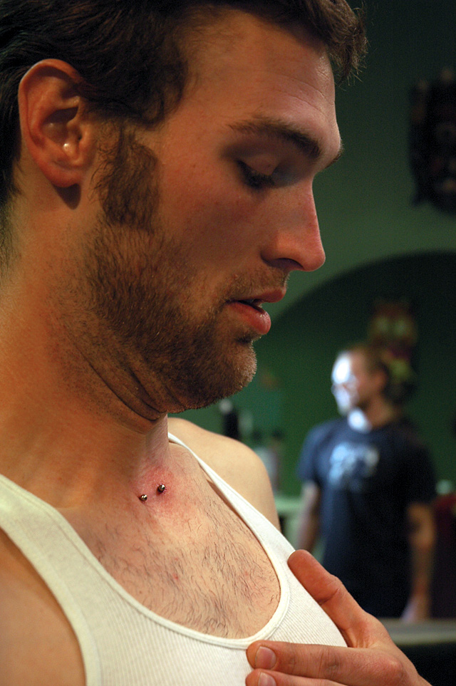 Bucky Jaquess tries to get a glance at the new piercing on his neck.