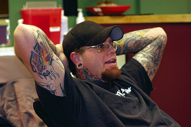 Jasen Phelps relaxes after a day of construction work and body piercing at Truth Tattoo.