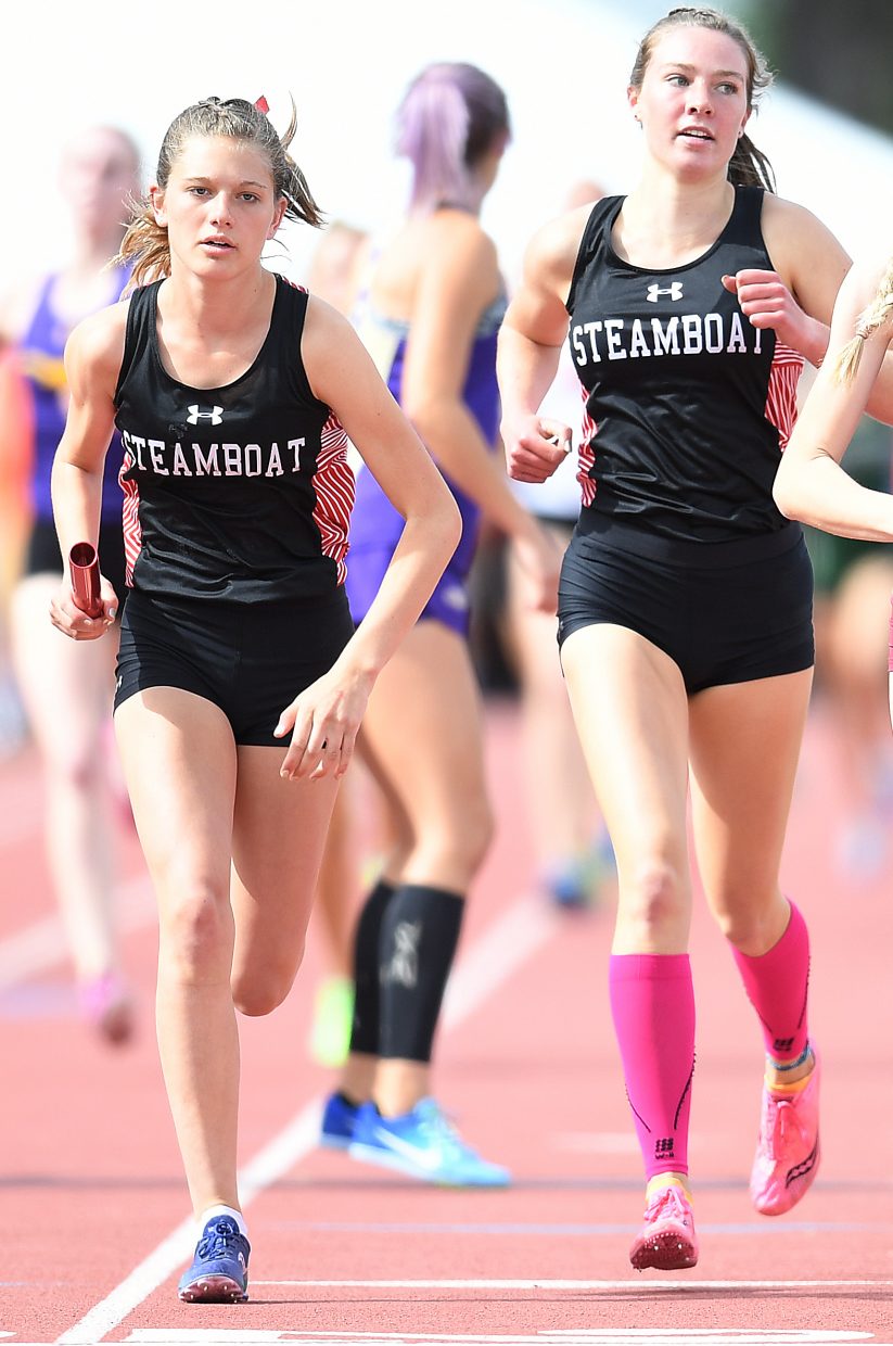 Isabelle Boniface takes off with the baton after Winter Boese finished the first leg of the girls 3A 3,200-meter relay on Thursday at the state track meet in Lakewood.