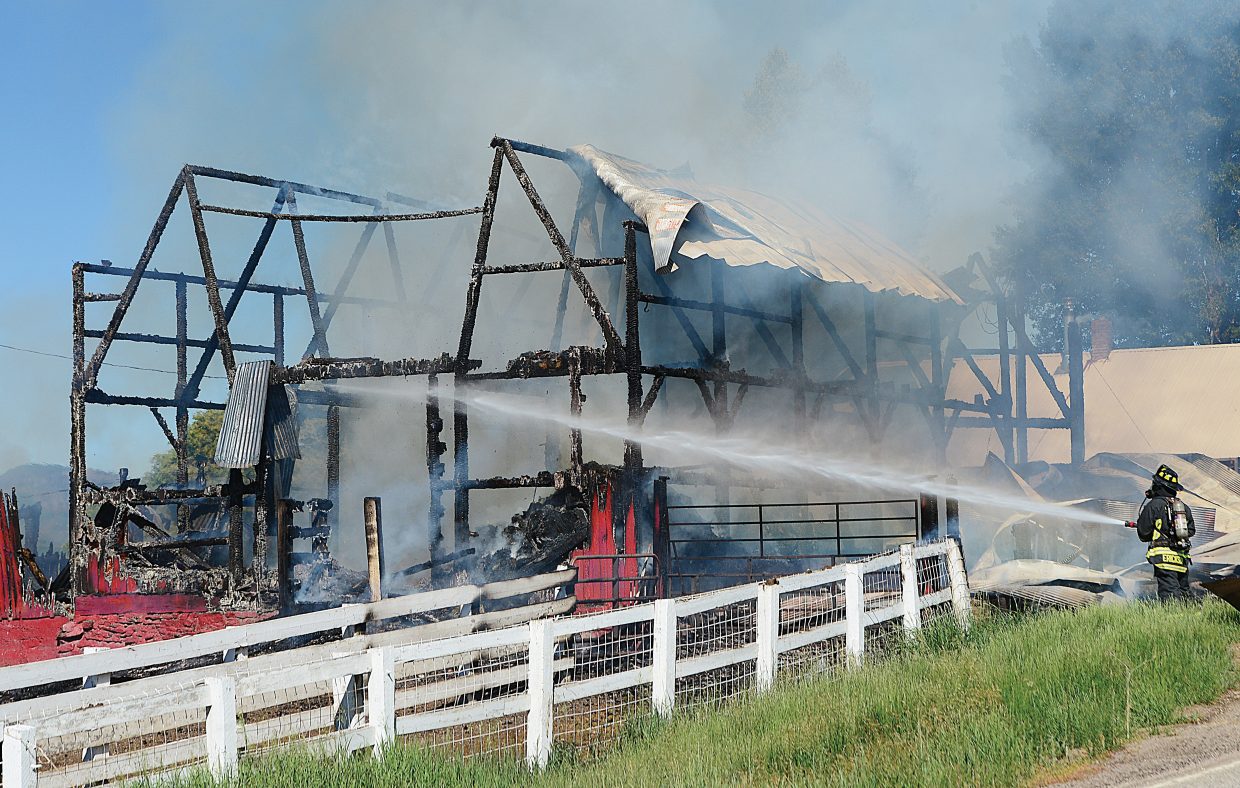 Steamboat Springs Fire Rescue's Scott Erickson extinguishes flames at a barn fire just off of Routt County Road 129. The blaze destroyed the iconic barn.