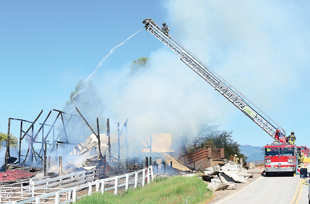 Firefighters use a ladder truck to battle a barn fire in North Routt County  Monday morning. The blaze destroyed the historic barn on the Circle Bar Ranch.