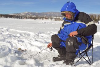 Jacob Griffith of Boulder works his line on Grand Lake Sunday during the Three Lakes Ice Fishing Contest.