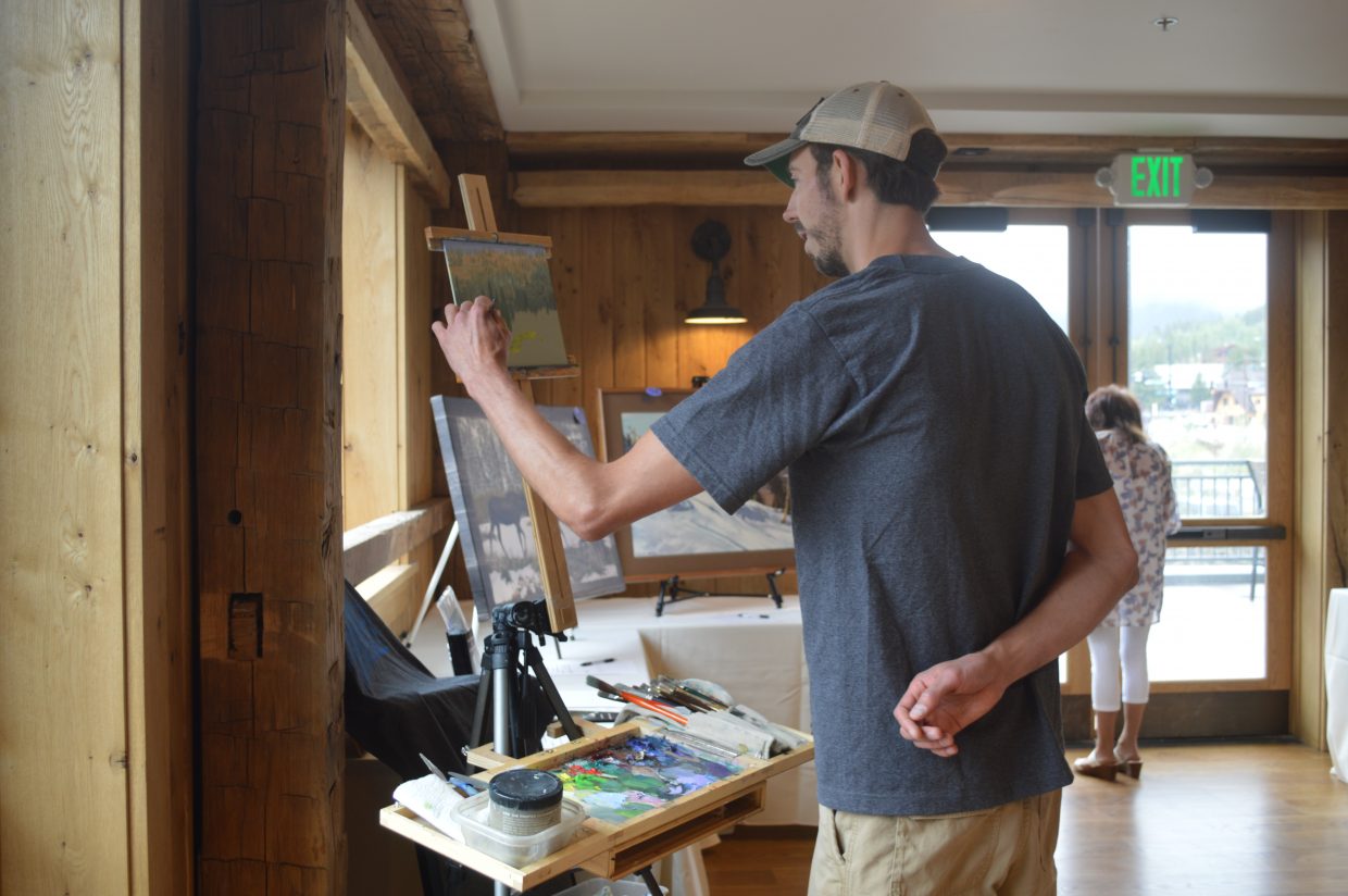 Local artist Jeff Bartholomew paints a landscape for the silent auction.