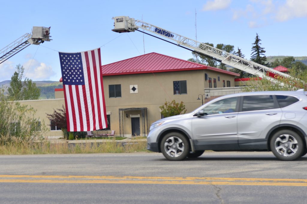 Drivers pass an American flag in front of the Grand Fire Protection District in this file photo.