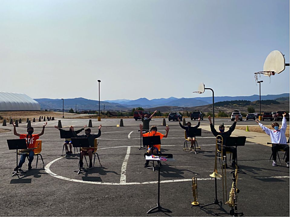 The EGMS eighth-grade band rehearses outside under the sun.