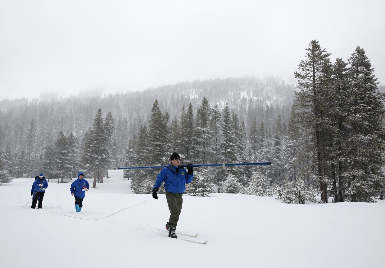 John King, right, of the Department of Water Resources, carries the snowpack measuring tube as he crosses a meadow while conducting the third manual snow survey of the season at the Phillips Station near Echo Summit, Calif., Thursday, Feb. 28, 2019. The survey found the snowpack at 113 inches deep with a snow water equivalent of 43.5 inches at this location at this time of year. 
