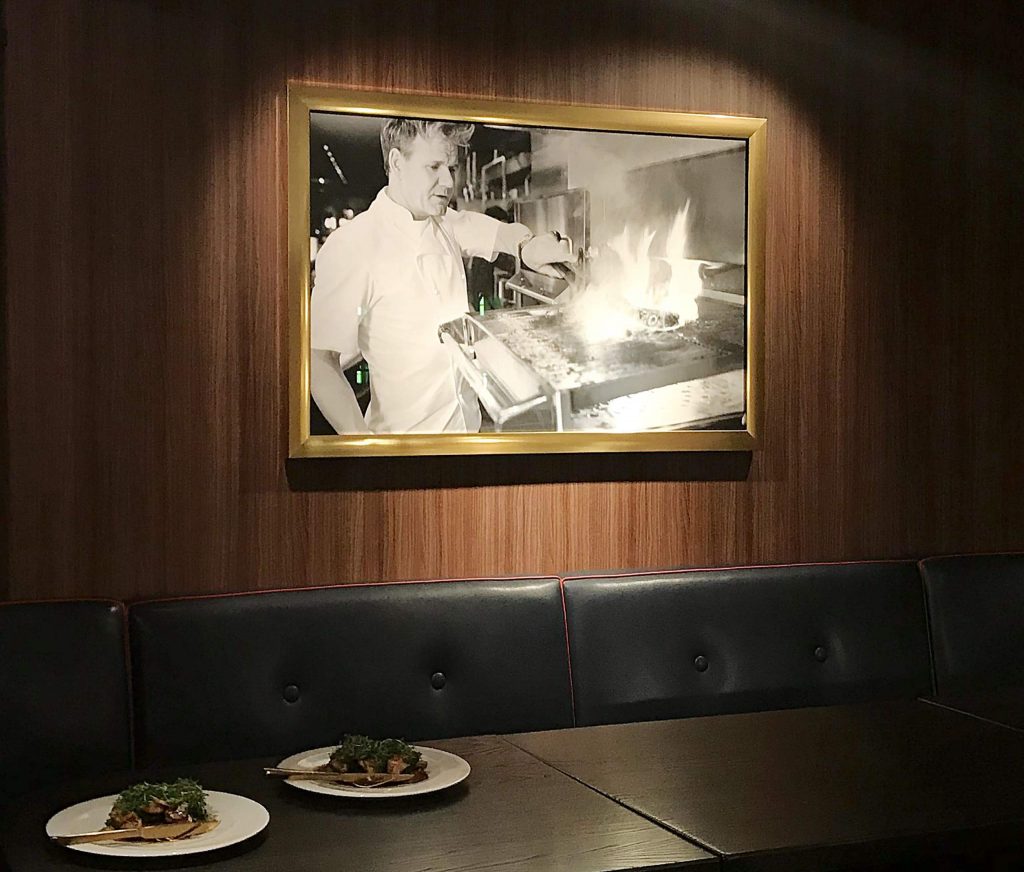 A black and white photo of Gordon Ramsey cooking.